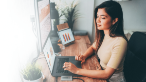 A girl is looking at her laptop and doing some work