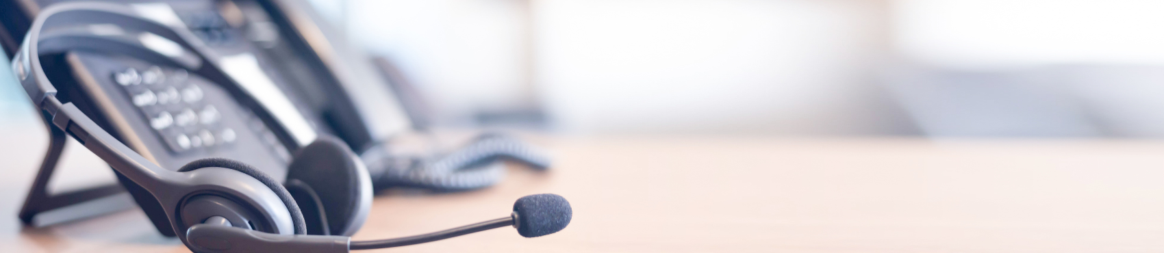 A telephome and a headphone placed next to each other representing customer care.